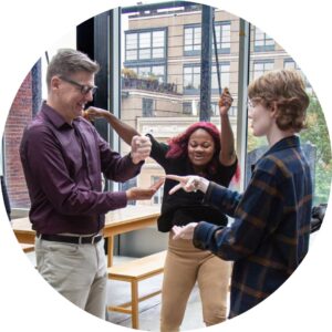 Three participants joyously engage in an improv workshops